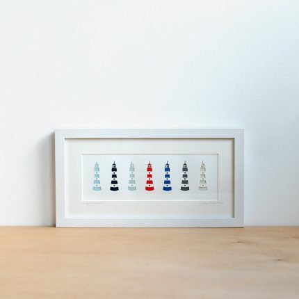 Framed artwork featuring a row of nautical colour paper cut lighthouses by Cornish Paper Cut Art