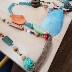 Examples of unique necklaces made from found materials at a workshop with Sarah Drew