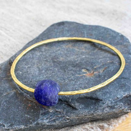 Brass bangle with dark blue bottle bead by Sarah Drew