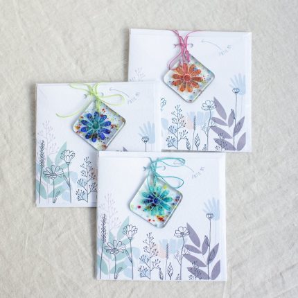 Group of three different coloured fused glass flower decorations with cards by Dreya Glass