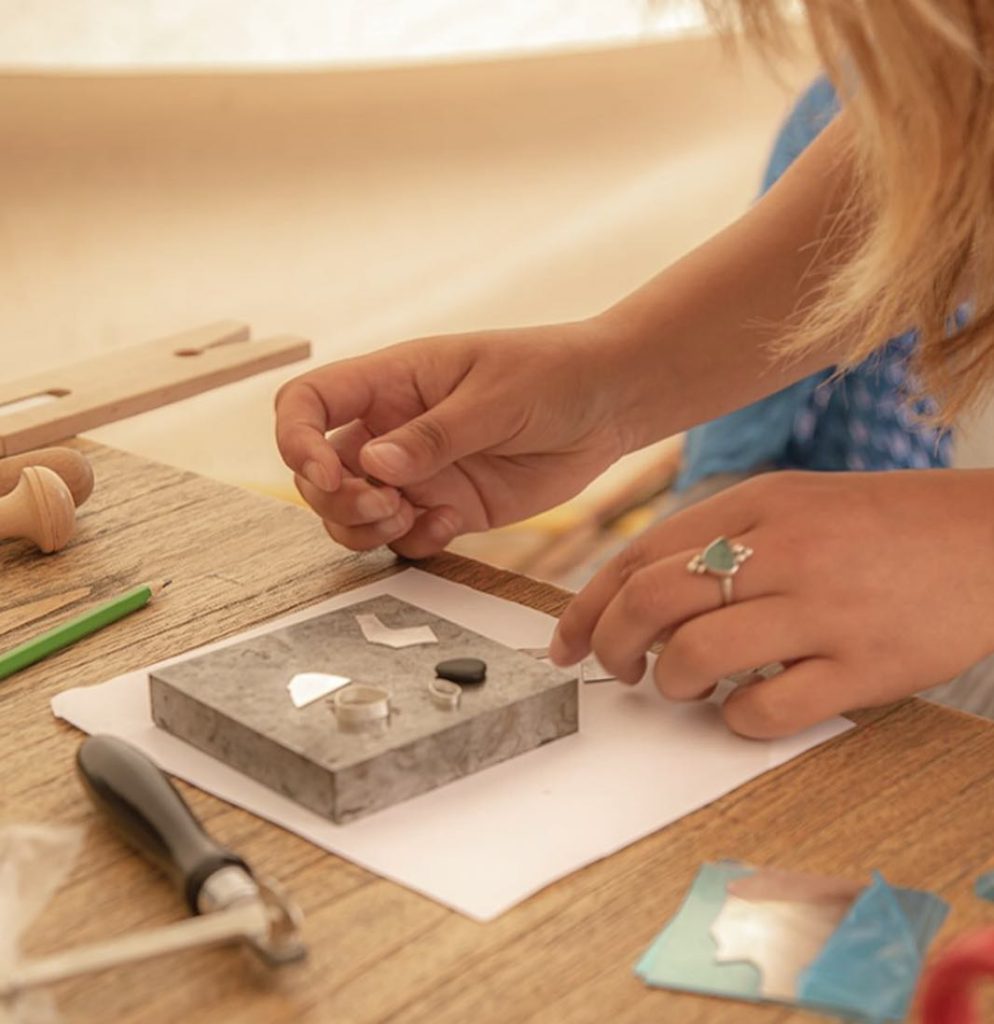 women working on a jewellery workshop bench