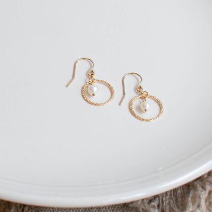 Pair of pearl and gold filled wire circle drop earrings by Sarah de Larrinaga