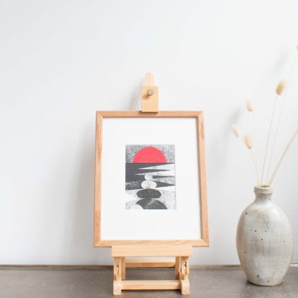 Original collage depicting black and white rocks with red sunset by Riverbird Studio, with white mount in an oak frame