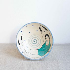 Handcrafted Cream Ceramic Bowl With A Blue Rim And Painted On The Inside With A Swimming Lady In Turquoise Costume And Goggles By Lucie Sivicka, Sitting On A Linen Table Cloth