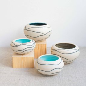 Group Of Four Ceramic Pebble Pots With Matt White Outside Decorated With Dark Grey Wavy Lines And Blue Glazed Inner, Handcrafted By Michelle Foote, Sitting On A Linen Table Cloth