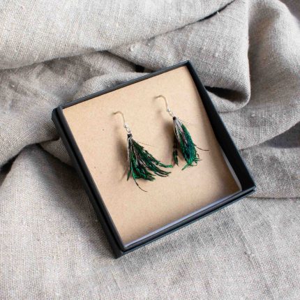 Pair of earrings made from green feathers displayed in black box on linen by Saffron & Peach