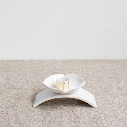 Porcelain candleholder with gold accents on a linen tablecloth by Frances Spice