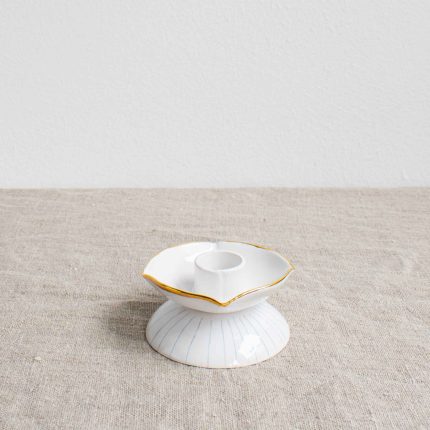 Porcelain candleholder with gold rim on a linen tablecloth by Frances Spice