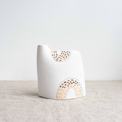 Porcelain vase with pale pink design and gold dots on a linen tablecloth by Frances Spice