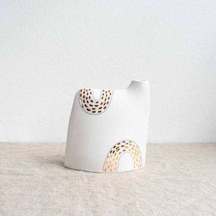 Porcelain vase with pale pink design and gold dots on a linen tablecloth by Frances Spice