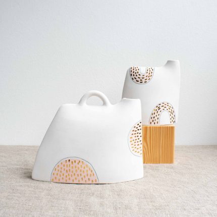 Two porcelain vases with pale pink design and gold dots on a linen tablecloth by Frances Spice