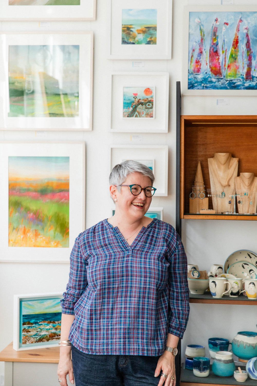 women standing in front of ceramics and artwork