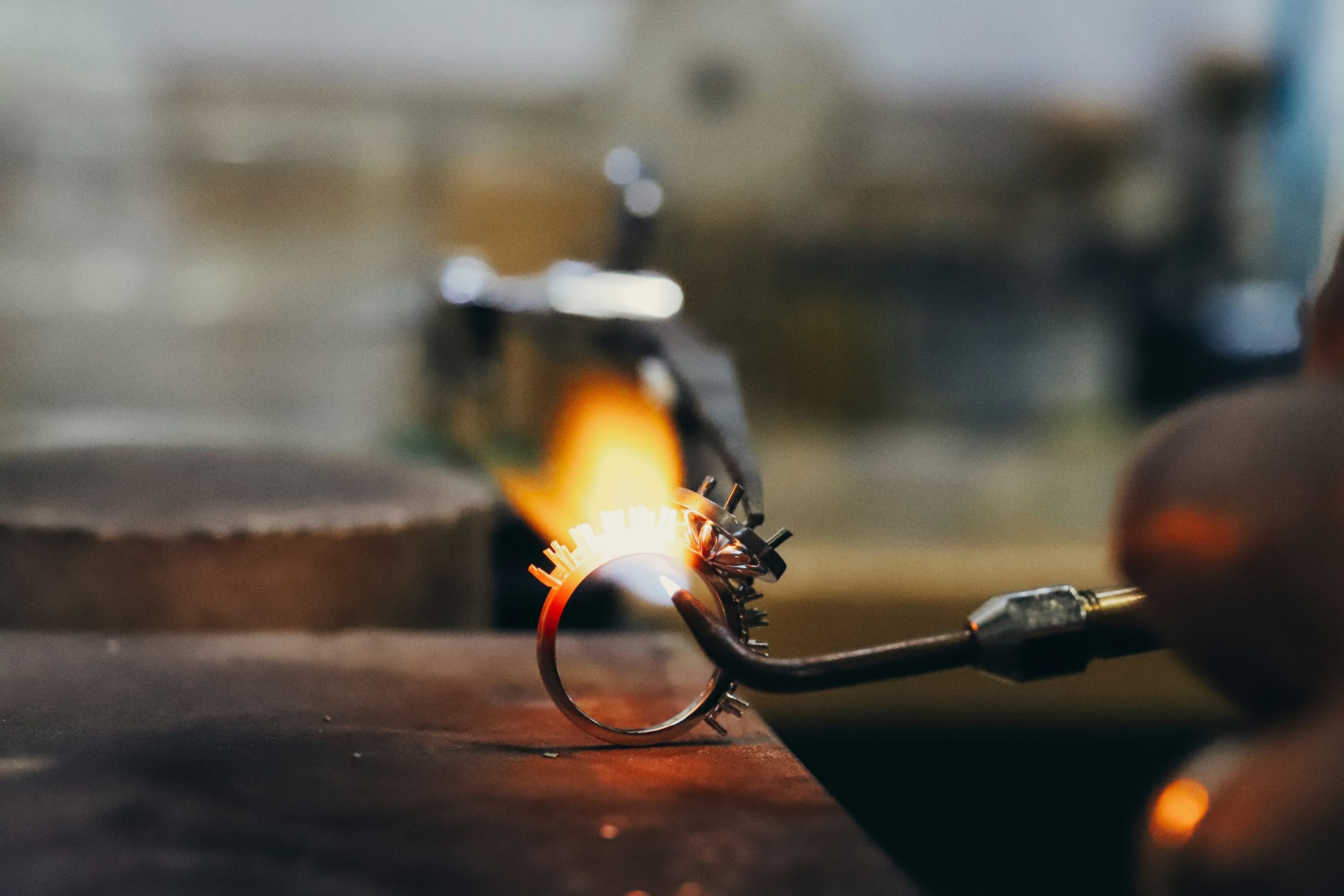 A silver ring being welded in a workshop